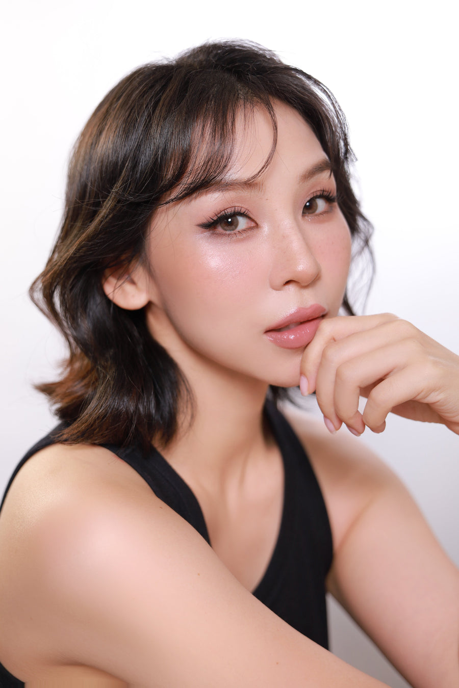 Woman with styled hair and makeup against a plain background